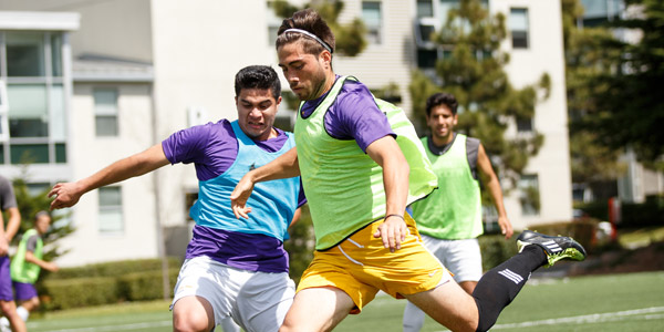 Male students playing a pick-up game of soccer